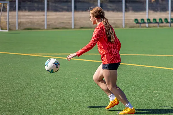 Girl playing soccer in a soccer field